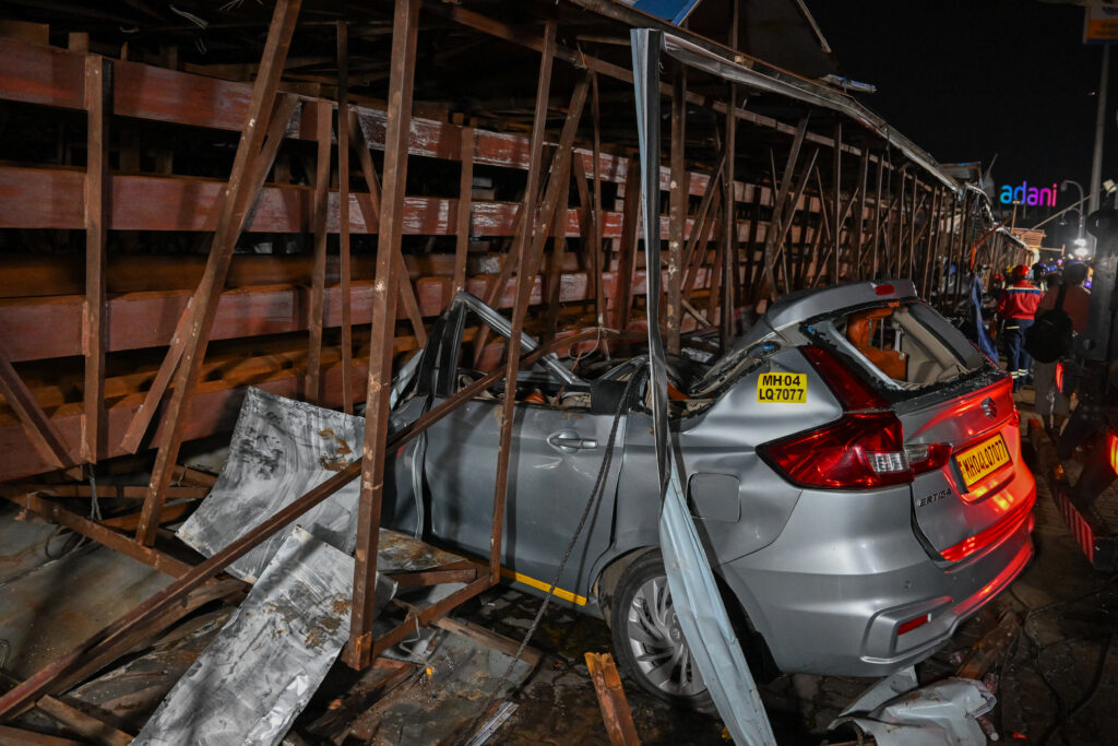 India billboard collapse: 12 dead, 60 injured. This photograph shows a heavily damaged car at the site where an advertisement billboard collapsed at a petrol station following a dust storm in Mumbai on May 13, 2024. (Photo by Punit PARANJPE / AFP)