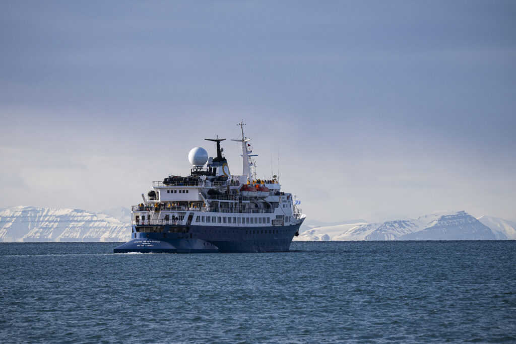 A boat with tourists onboard leaves Longyearbyen, located on Spitsbergen island, in Svalbard Archipelago, northern Norway, on May 16, 2024. (Photo by Jonathan NACKSTRAND / AFP)