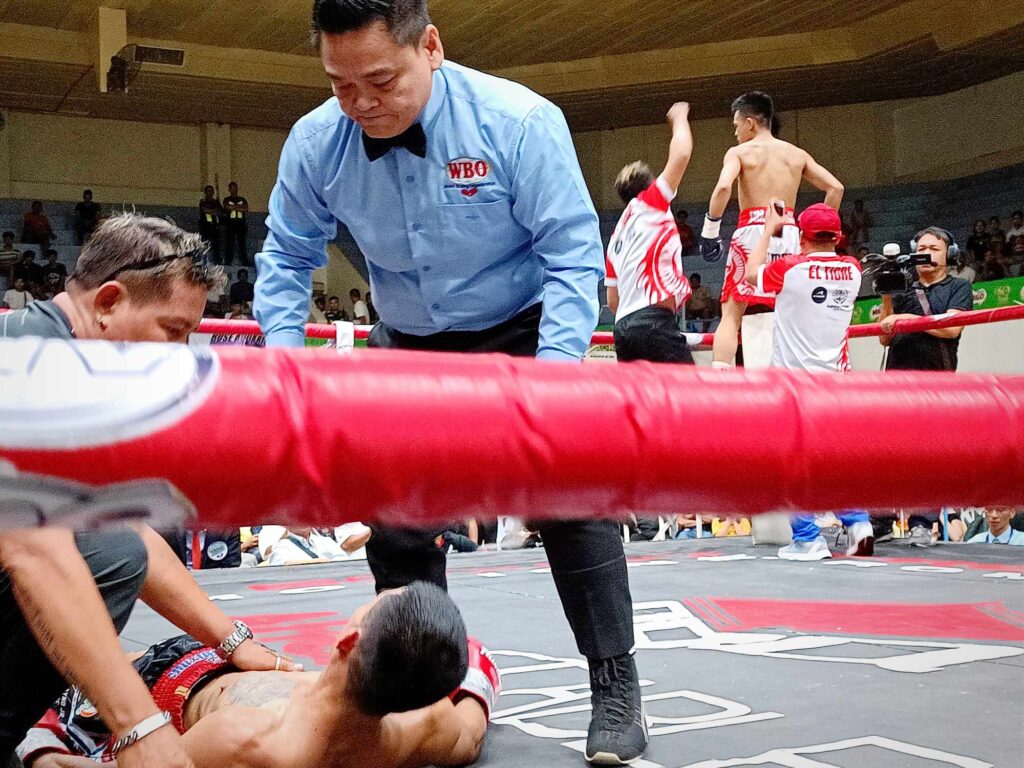 GAB requested to review controversial Macado-Dumam-ag fight. International referee Danrex Tapdasan (standing) and ARQ Boxing Stable trainer Eldo Cortes are seen helping Ramel Macado Jr. who is lying flat on his back after getting knocked out by Lorenz Dumam-ag. | Glendale Rosal