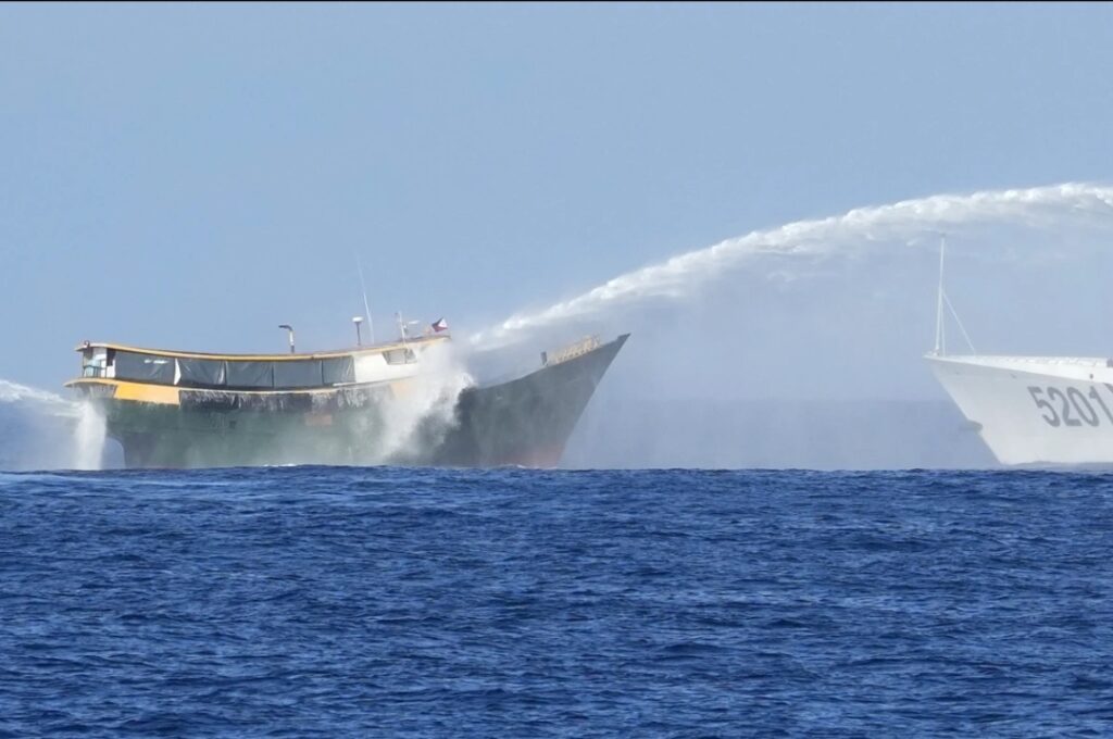 FILE- Philippine resupply vessel Unaizah May 4,left, is hit by two Chinese coast guard water canons as they tried to enter the Second Thomas Shoal, locally known as Ayungin Shoal, in the disputed South China Sea on March 5, 2024. For the first time, China has publicized what it claims is an unwritten 2016 agreement with the Philippines over access to South China Sea islands.