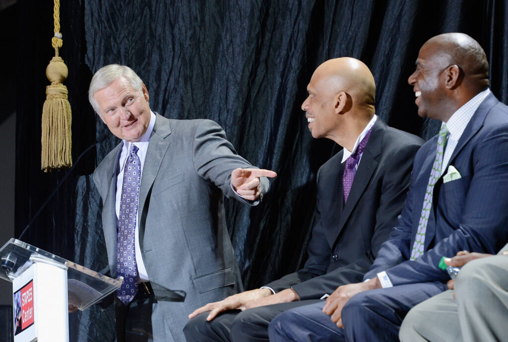 (FILES) Former Los Angeles Lakers' general manager Jerry West (L) points to Lakers legend Kareem Abdul-Jabbar (C) and Earvin "Magic" Johnson during a ceremony where Abdul-Jabbar unveiled a statue of himself at Staples Center in Los Angeles on November 16, 2012. 