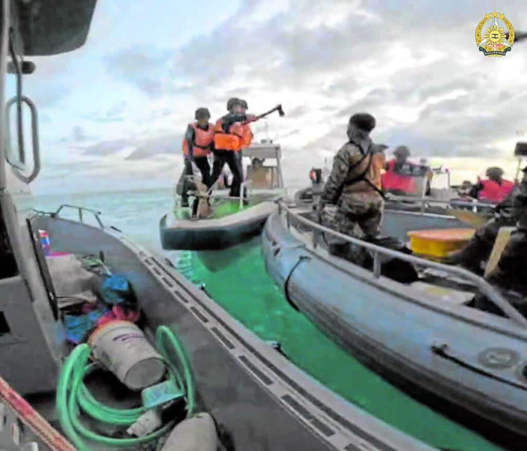 China Coast Guard used bolos, acted like pirates - AFP. (WEAPON IN HAND) In photo, The Armed Forces of the Philippines, which released this photo on Wednesday, is saying one of the China Coast Guard members shown here (center) wielded a pickaxe and made threatening gestures in their encounter with Filipino troops on a resupply mission to Ayungin (Second Thomas) Shoal on June 17.