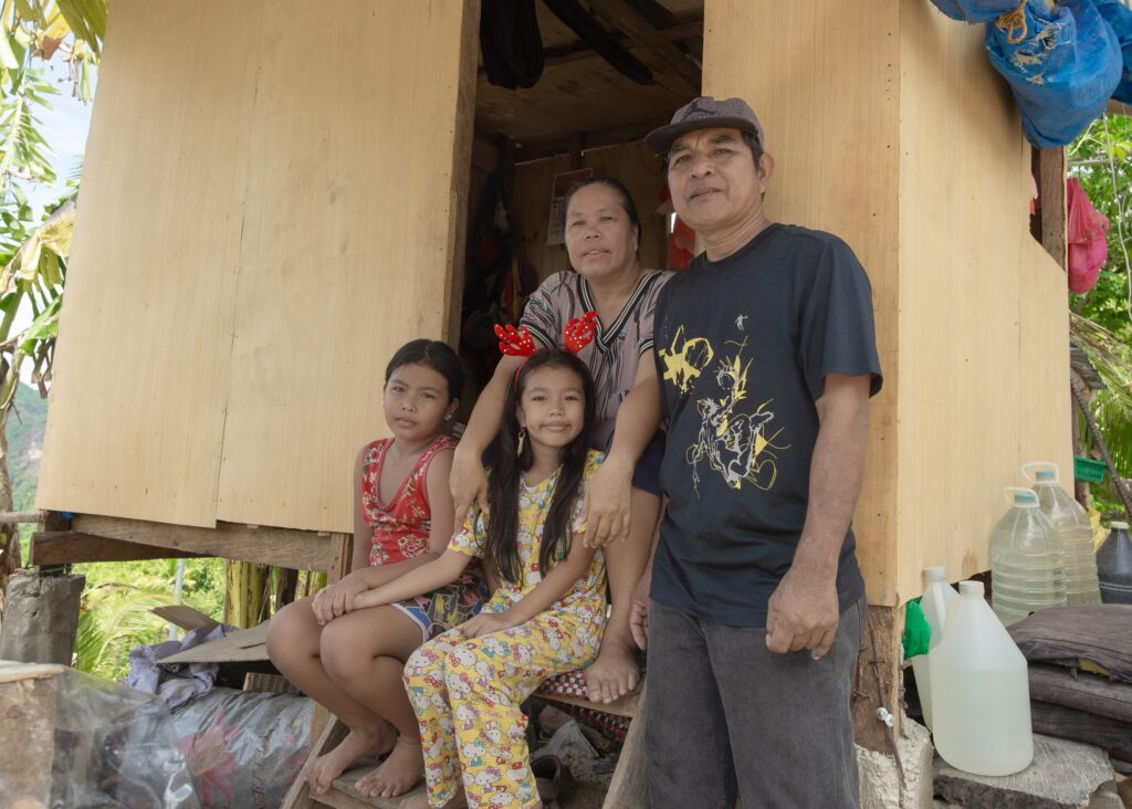 Arnulfo and his family pose at the entrance of their love-wrapped home. 