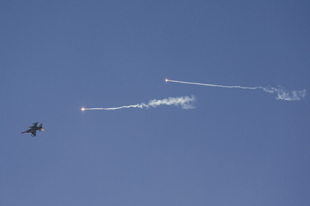 Hezbollah targets Israeli mountain base in 'largest' air attack. This picture taken from a position in northern Israel shows an Israeli Air Force fighter jet firing flares as it flies to intercept a hostile craft that launched from Lebanon over the border area with south Lebanon on July 7, 2024, amid ongoing cross-border clashes between Israeli troops and Hezbollah fighters. (Photo by Jalaa MAREY / AFP)