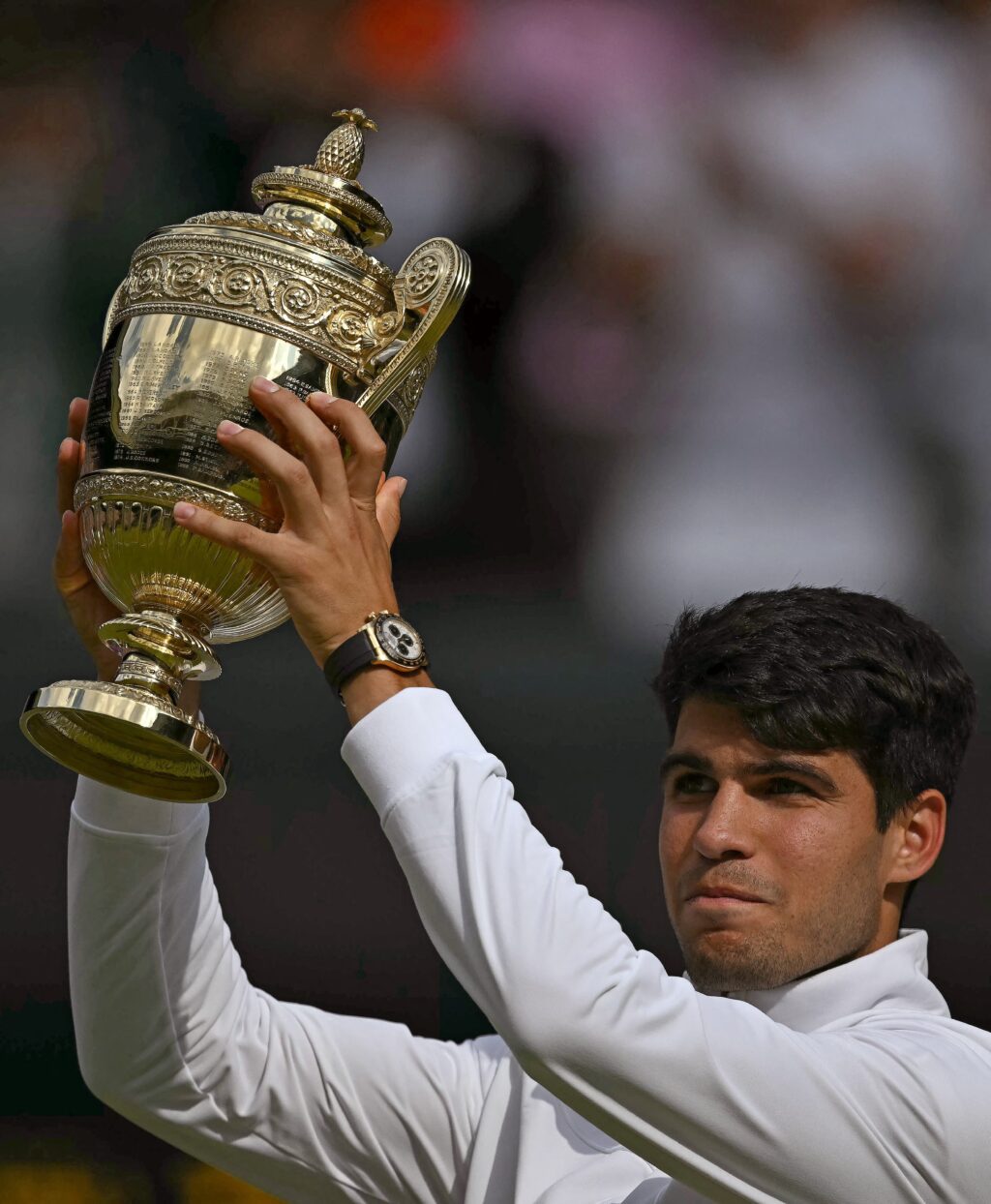 Spain's Carlos Alcaraz poses with the winner's trophy after beating Serbia's Novak Djokovic during their men's singles final tennis match on the fourteenth day of the 2024 Wimbledon Championships at The All England Lawn Tennis and Croquet Club in Wimbledon, southwest London, on July 14, 2024. | AFP