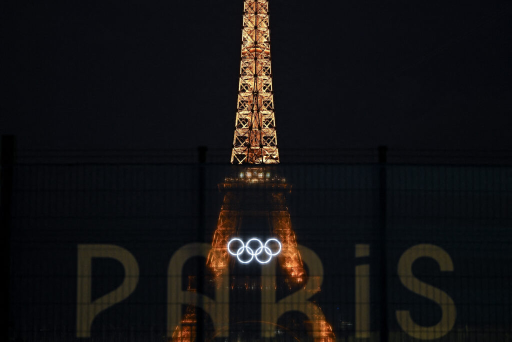 Paris Olympics opening ceremony: What we know about it. This photograph shows the Eiffel Tower bearing the Olympics rings, lit-up ahead of the Paris 2024 Olympic and Paralympic games, in Paris on July 20, 2024. (Photo by MANAN VATSYAYANA / AFP)