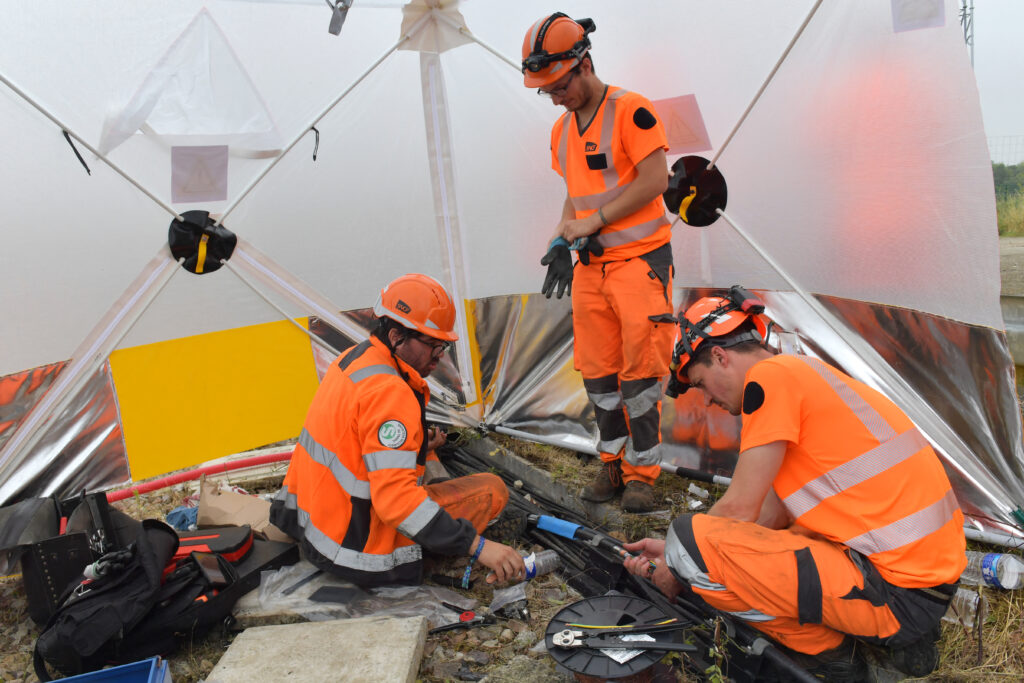 'Sabotage' on French rail network before Olympics: What we know. Workers operate to reconnect the signal box to the track in its technical ducts in Vald' Yerres, near Chartres on July 26, 2024, as France's high-speed rail network was hit by an attack disrupting the transport system, hours before the opening ceremony of the Paris 2024 Olympic Games. According to the French railway company SNCF, a massive attack on a large scale hit the high speed train network (TGV) on July 26, 2024, and many routes will have to be cancelled. The SNCF urged passengers to postpone their trips and stay away from train stations. (Photo by JEAN-FRANCOIS MONIER / AFP)