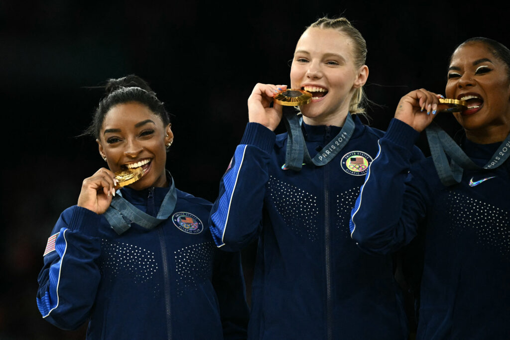 US' Simone Biles and teammates pose with the gold medal during the podium ceremony for the artistic gymnastics women's team final during the Paris 2024 Olympic Games at the Bercy Arena in Paris, on July 30, 2024. (Photo by Lionel BONAVENTURE / AFP)