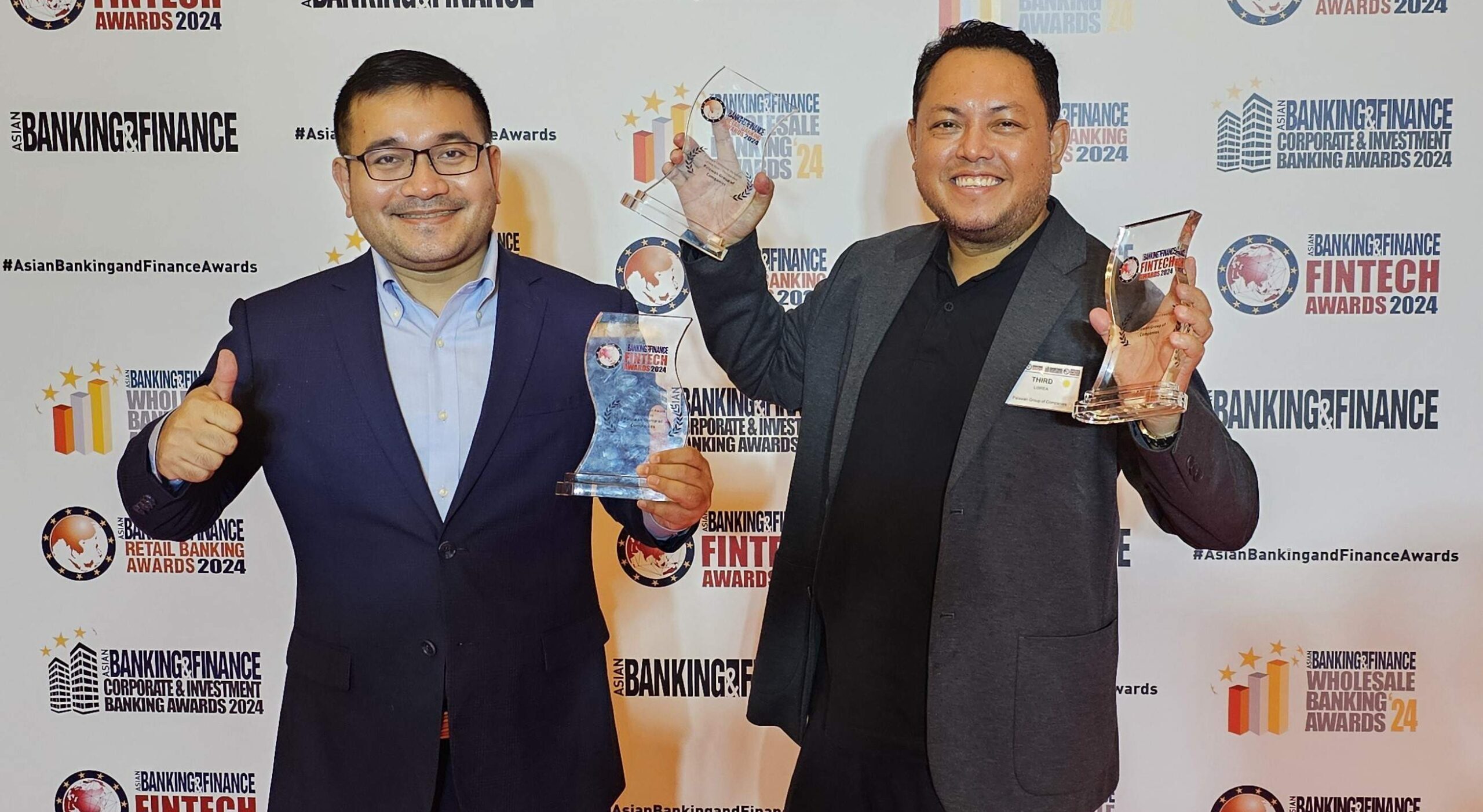 Palawan Financial Services Corporation's executives, Bernard Kaibigan, Head of Marketing, and Third Librea, President and CEO, celebrating their triple victory at the Asian Banking Finance Fintech and Retail Awards 2024, championing finance