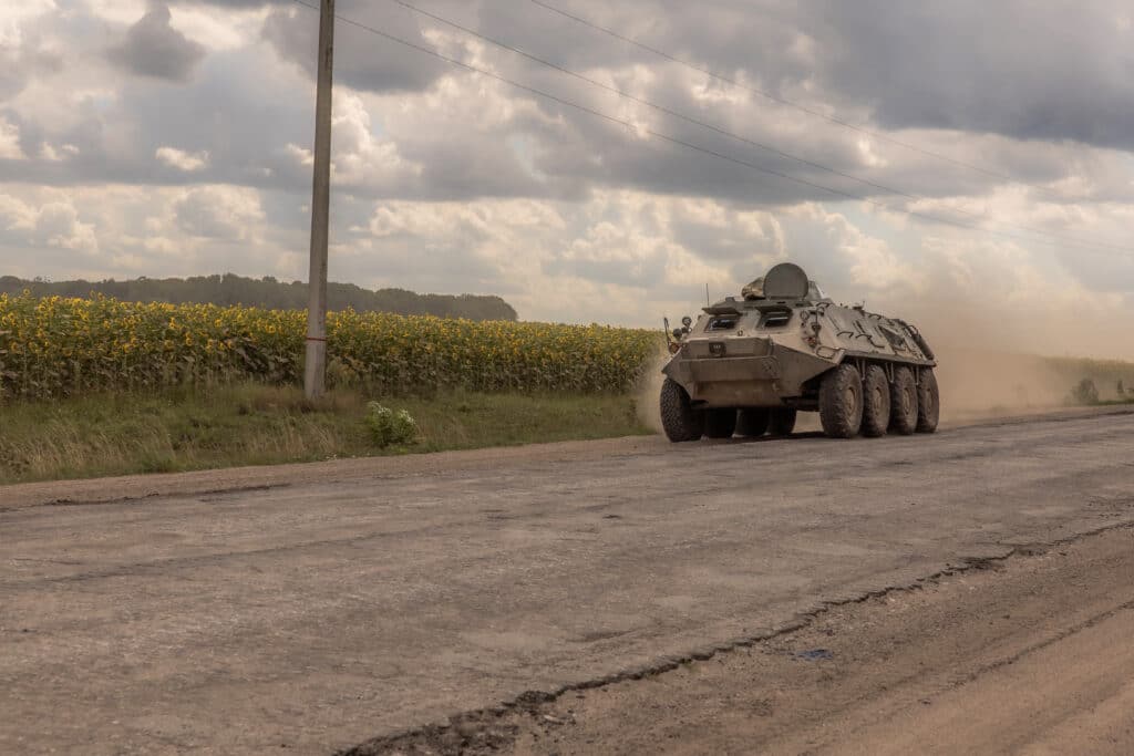 Ukraine: Thousands of troops join incursion to destablize Russia. Ukrainian servicemen drive a Soviet-made armored personnel carrier past fields of sunflowers in the Sumy region, near the border with Russia, on August 11, 2024, amid the Russian invasion of Ukraine. | Photo by Roman PILIPEY / AFP