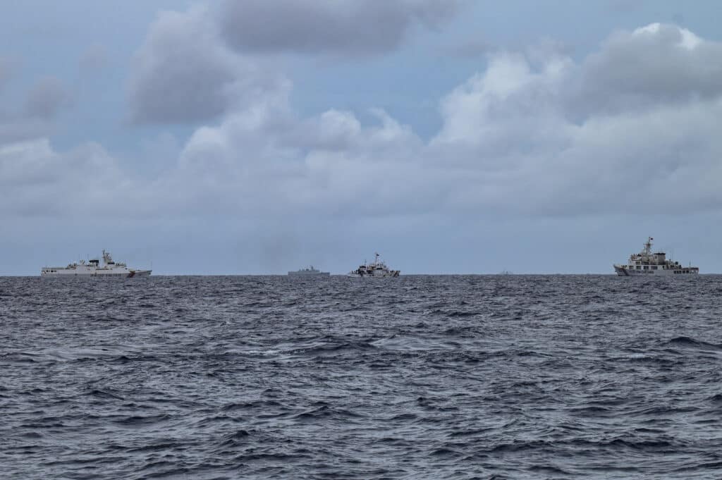 Filipino sailors hold the line at flashpoint South China Sea reef. In photo are China Coast Guard ships (left and right) and a vessel identified by the Philippine Coast Guard as a Chinese navy ship (centre left, in background) are seen by the Philippine Coast Guard ship BRP Cape Engaño (centre right), as photographed from the BRP Cabra during a supply mission to Sabina Shoal in disputed waters of the South China Sea on August 26, 2024. | Photo by Jam Sta Rosa / AFP