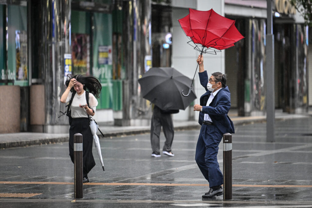 Powerful Typhoon Shanshan slams into southern Japan. In photo is a man holding his umbrella in the wind outside Hakata station in Fukuoka, Japan, on August 29, 2024.| Photo by Yuichi YAMAZAKI / AFP