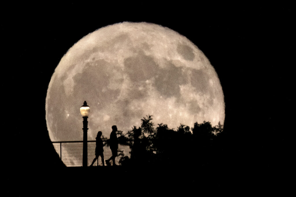 August's supermoon is first of four lunar spectacles. People walk in front of a rising supermoon at Griffith Observatory in Los Angeles, Monday, Aug. 19, 2024. (AP Photo/Richard Vogel)