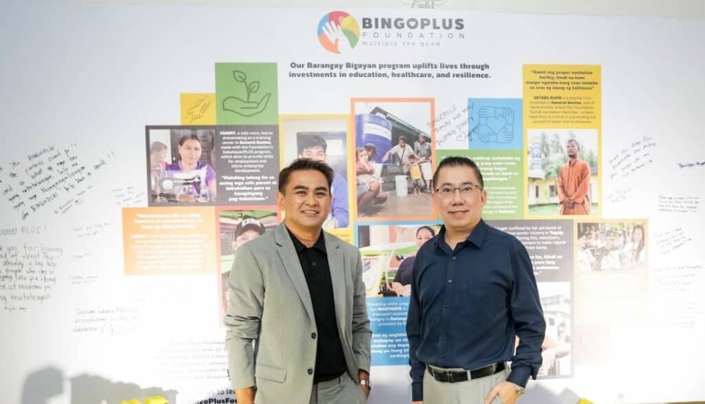 President Andy Tsui of DigiPlus and President Jasper Vicencio of AB Leisure Exponent, Inc. standing in front of the BingoPlus Foundation wall.