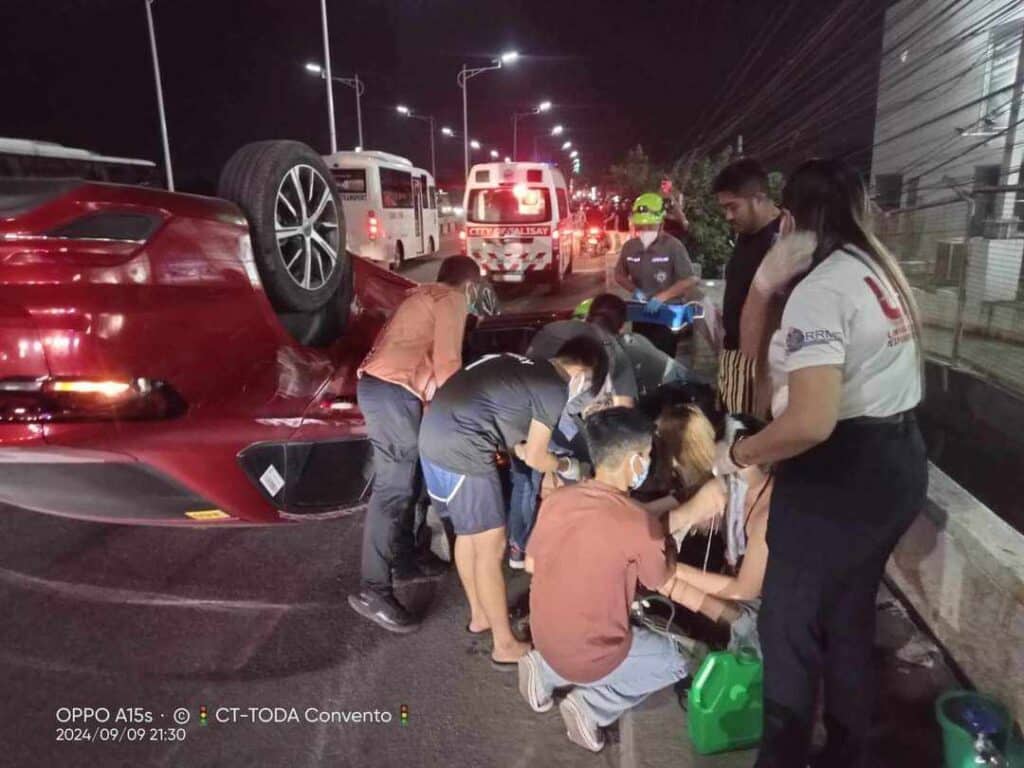 Talisay accident: Car hits railings, flips, lands on its roof. In photo are emergency responders of Talisay City giving first aid to slightly injured victims of the car crash on September 9. | CT-TODA photo via Futch Anthony Inso