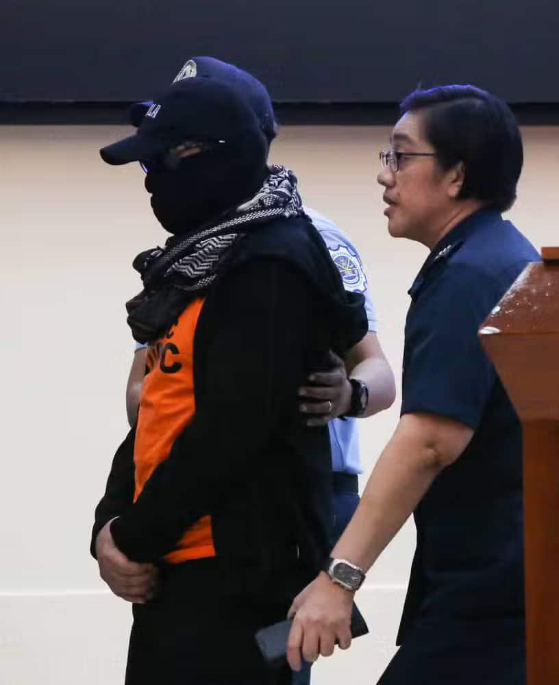 Escorted by police, including PNP Spokesperson PCol. Jean Fajardo (right), televangelist Apollo Quiboloy, preacher of the Kingdom of Jesus Christ, The Name Above All Names, Inc. exits the PNP Multipurpose hall for the DILG-PNP press conference following his arrest. —Inquirer photo/Lyn Rillon