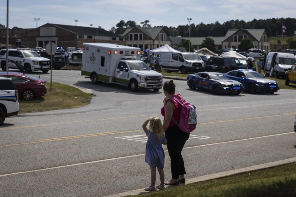 US school shooting: 4 killed by 14-year-old gunman. In photo are a young girl and her mother watching as law enforcement and first responders surround Apalachee High School in Winder, Georgia, on September 4, 2024, after a shooting was reported.  | Photo by CHRISTIAN MONTERROSA / AFP