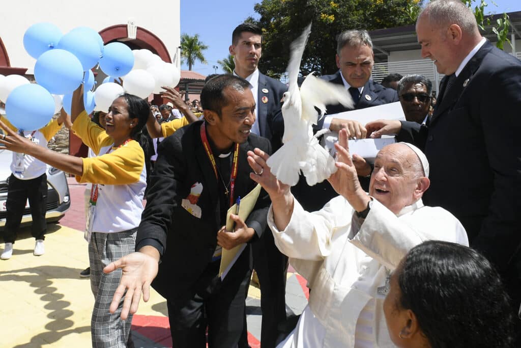 This handout photo taken and released on September 11, 2024 by the Vatican Media shows Pope Francis (2nd R) releasing a dove as he arrives for meeting with young people at the Centro de Convercoies in Dili. | Photo by Handout / VATICAN MEDIA / AFP