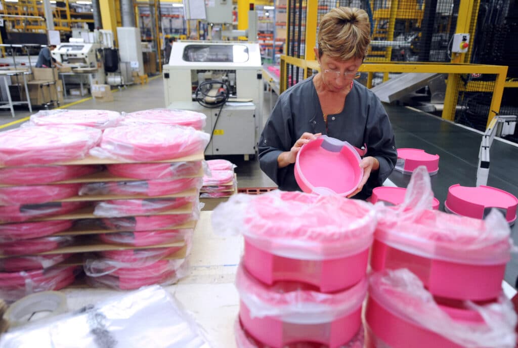 (FILES) An employee of Tupperware Brands Corporation is at work on the production line, on August 27, 2013 at the group's plant in Joue-les-Tours, centre France, on the day of its 40th anniversary. | Photo by JEAN-FRANCOIS MONIER / AFP