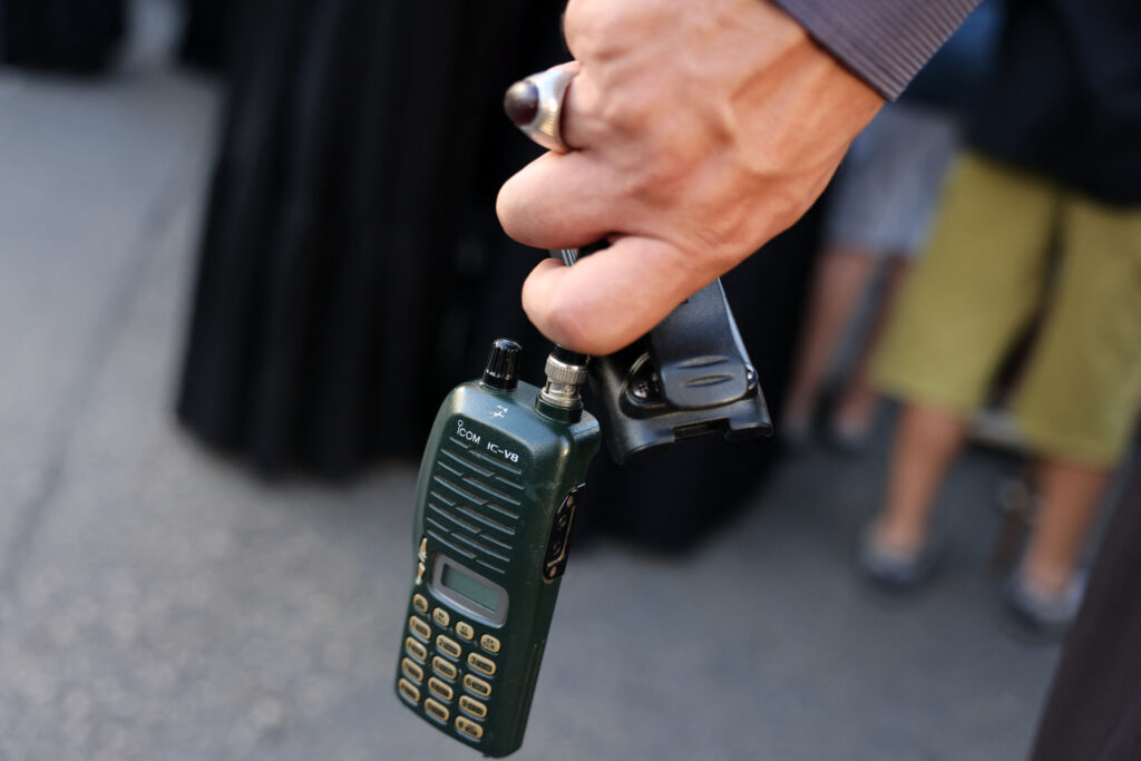 A man holds a walkie talkie device after he removed the battery during the funeral of persons killed when hundreds of paging devices exploded in a deadly wave across Lebanon the previous day, in Beirut's southern suburbs on September 18, 2024. | Photo by ANWAR AMRO / AFP