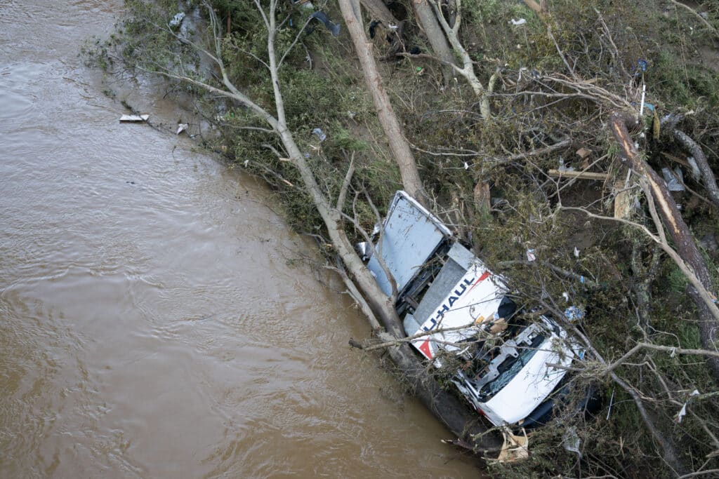 A storm-damaged U-Haul pickup truck sits along a flooded waterway in the aftermath of Hurricane Helene on September 29, 2024 | Photo by Sean Rayford Getty Images via AFP