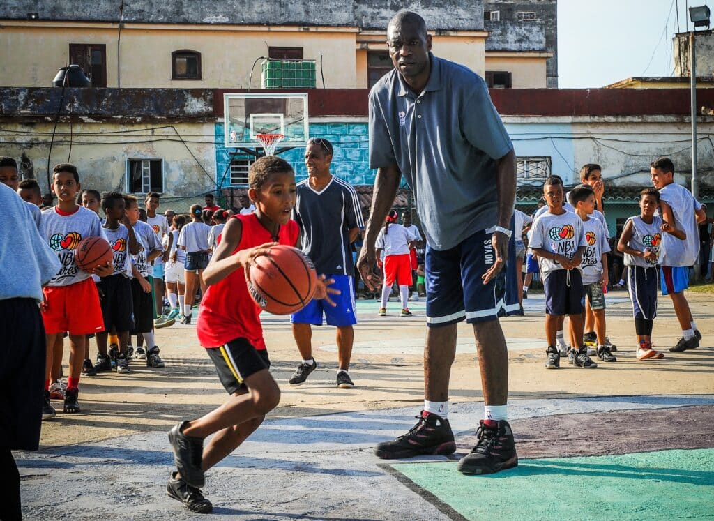 NBA: Basketball great Mutombo dies aged 58. In photo is former NBA basketball player Dikembe Mutombo (center) giving instructions to Cuban children during clinical organized by the NBA, FIBA Americas and Cuban Basketball Federation on April 24, 2015, in Havana. | Photo by Yamil LAGE / AFP [FILE PHOTO]