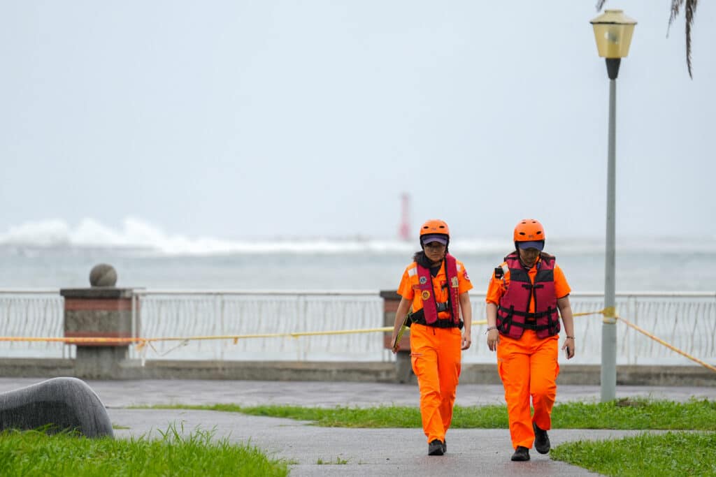 Coast Guard members walk along the shore at Sizihwan beach in Kaohsiung as super typhoon Krathon moved towards Taiwan on October 1, 2024. (Photo by WALID BERRAZEG / AFP)