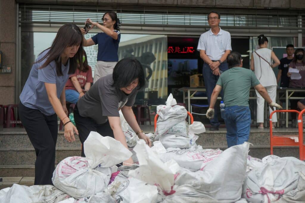 People carry sand bags from city government district offices for distribution in Kaohsiung as super typhoon Krathon moved towards Taiwan on October 1, 2024. (Photo by WALID BERRAZEG / AFP)