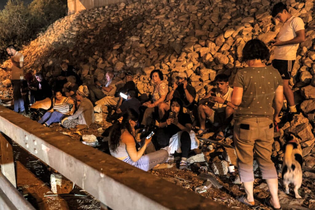 People take cover under a bridge along a highway between Kafr Qara and Baqa al-Gharbiya in northern Israel on October 1, 2024. Photo by Ahmad GHARABLI / AFP