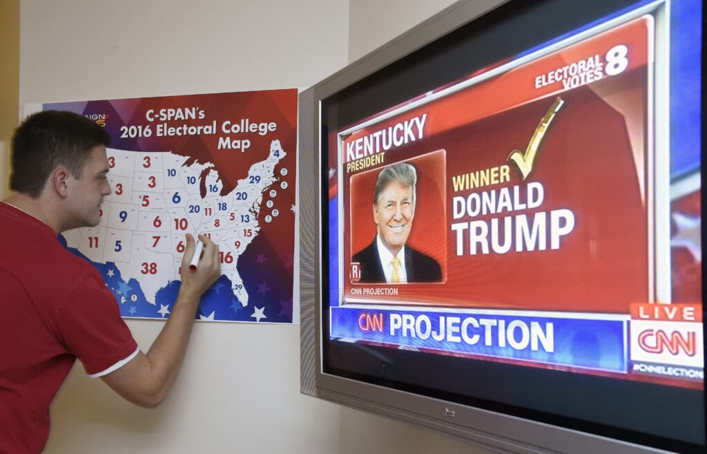 Win the vote but still lose? Behold America's Electoral College. (FILES) Jake Krupa colors in an electoral map as states are projected for Republican presidential candidate Donald Trump or Democratic Presidential candidate Hillary Clinton at an election watching party in Coconut Grove, Florida, on November 8, 2016. | Photo by RHONA WISE / AFP [FILE PHOTO]