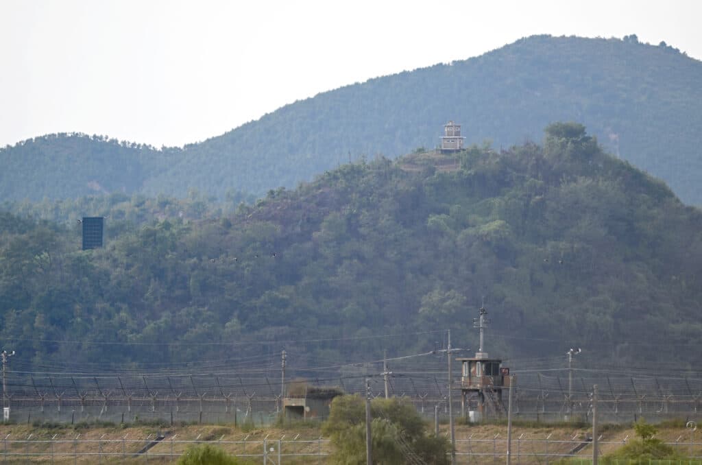 A North Korean guard post (R top) and a loudspeaker (L) on the North side of the Demilitarized Zone (DMZ) dividing the two Koreas, are seen over a South Korean guard post (bottom) from the border city of Paju on October 9, 2024. | Photo by Jung Yeon-je / AFP