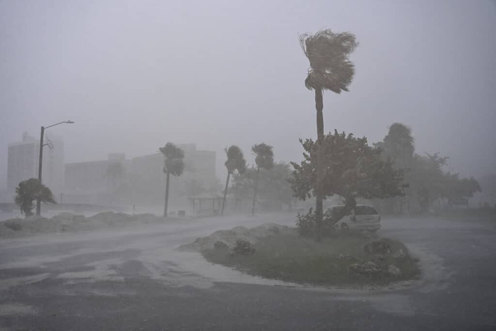 A car is seen parked as it rains heavily in Fort Myers, Florida, on October 9, 2024 as Hurricane Milton approaches. | Photo by CHANDAN KHANNA / AFP