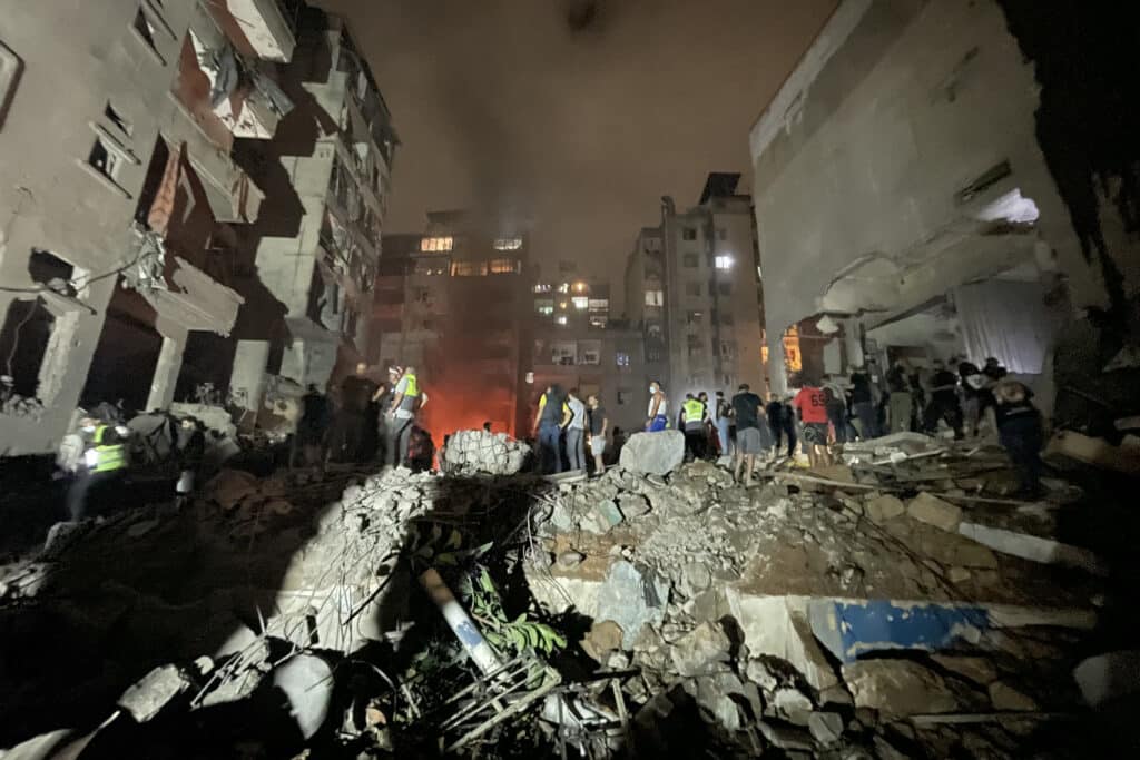 Israel strikes central Beirut, killing 22. In photo are Lebanese civil defence members and other people inspecting the site of an Israeli airstrike on the Basta neighbourhood of Beirut on October 10, 2024. | Photo by Hassan FNEICH / AFP