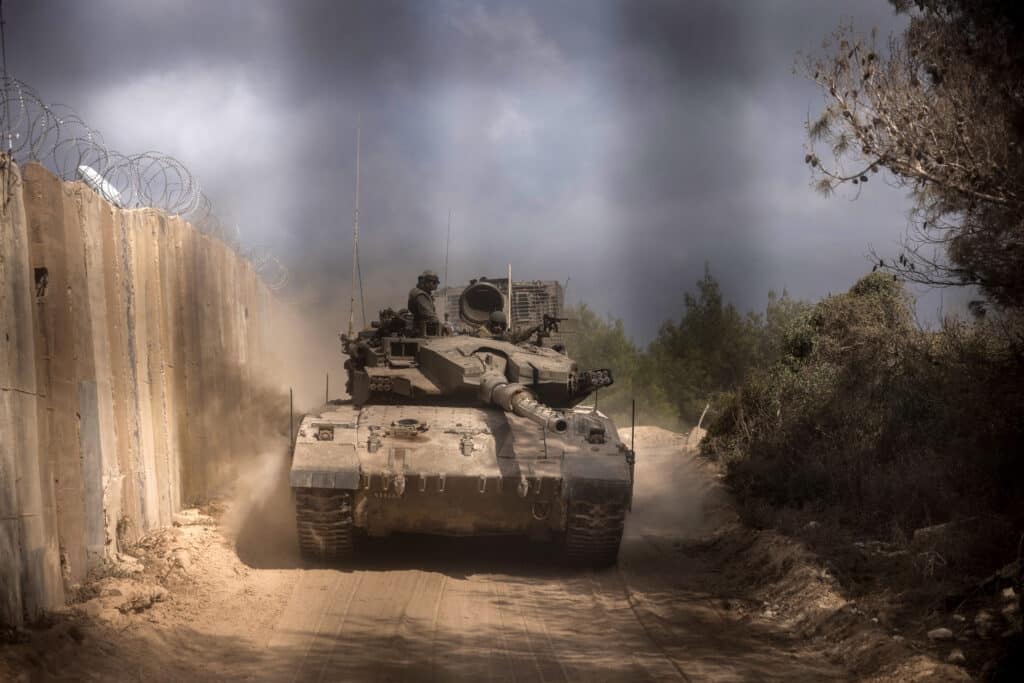 This picture taken on October 13, 2024 shows an Israeli battle tank entering Lebanon from northern Israel at the southern Lebanese border point of Naqoura. | Photo by Menahem KAHANA / AFP