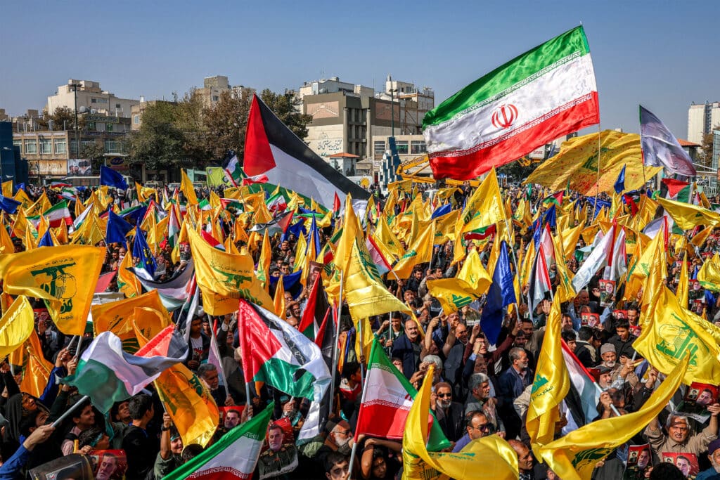 Israel pounds Hezbollah strongholds in Lebanon, killing mayor. Mourners wave flags of Iran, Palestine, and Hezbollah during the funerary procession of Abbas Nilforoushan, the slain commander of Iran's Islamic Revolutionary Guards (IRGC) who was killed in an Israeli air strike on Beirut's southern suburbs in late September, in Mashhad in southern Iran on October 16, 2024. | Photo by Seyed Mohammad Alerasool / ISNA / AFP