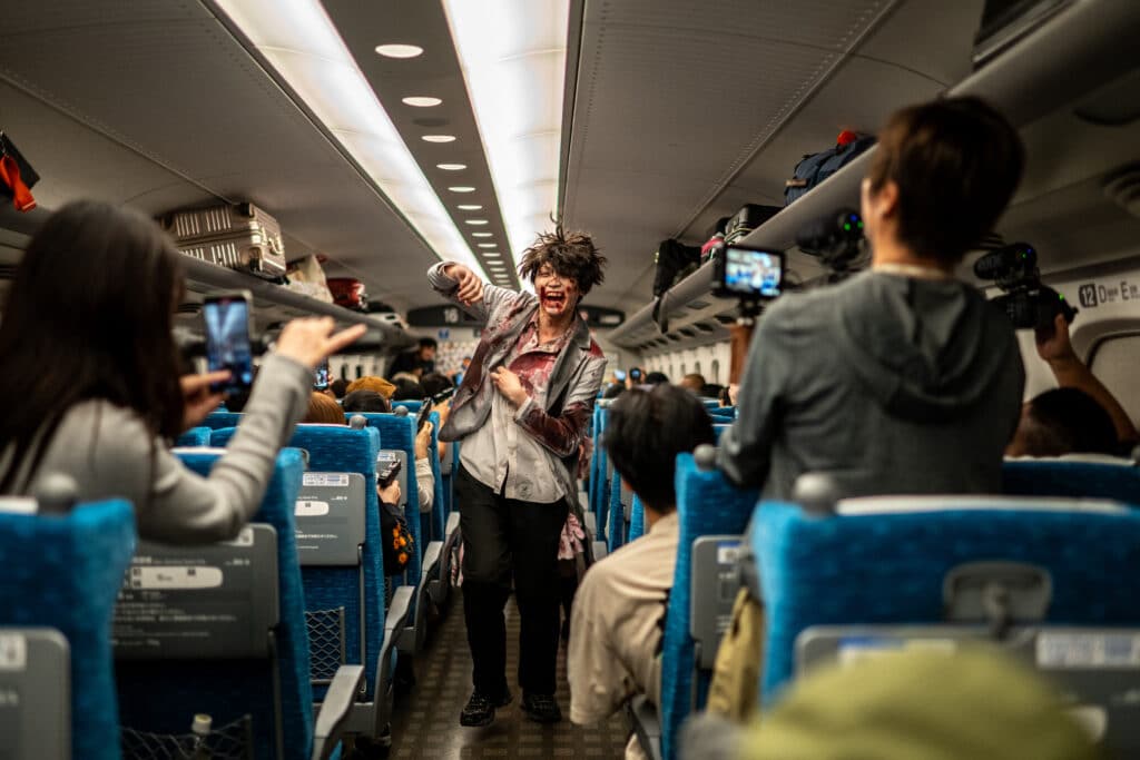 An actor performs for passengers during the 'Zombie Shinkansen' event on a bullet train from Tokyo to Osaka, ahead of Halloween on October 19, 2024. | Photo by Philip FONG / AFP