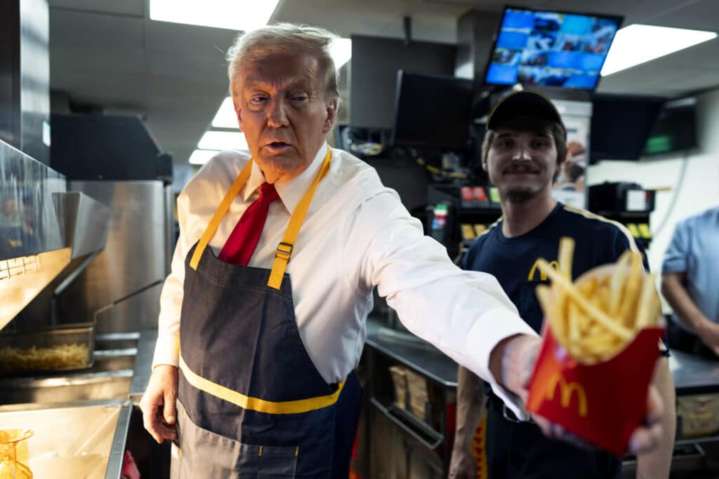 Republican presidential nominee, former U.S. President Donald Trump works behind the counter during a visit to McDonald's restaurant on October 20, 2024 in Feasterville-Trevose, Pennsylvania. | Photo by POOL / Getty Images via AFP