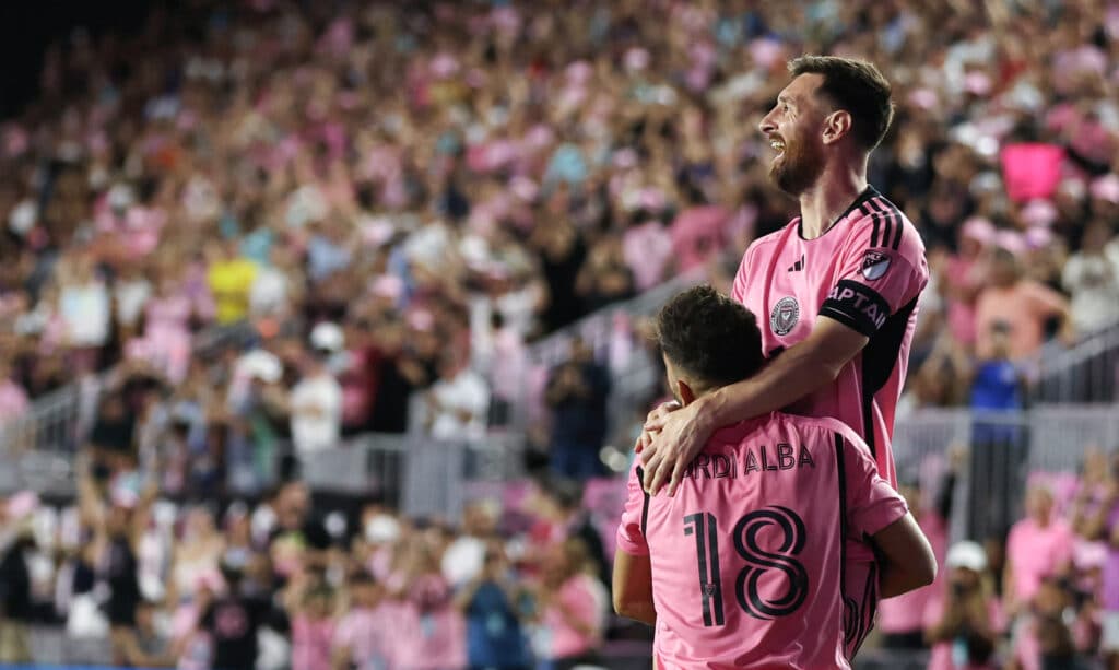 Inter Miami's Argentine forward #10 Lionel Messi celebrates with teammate Spanish defender #18 Jordi Alba after scoring his team's fourth goal during the Major League Soccer (MLS) football match between Inter Miami and New England Revolution at Chase Stadium in Fort Lauderdale, Florida, October 19, 2024. (Photo by Chris Arjoon / AFP)