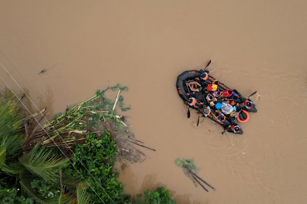 Kristine batters Luzon: 14 dead, thousands evacuated, An aerial view shows a coast guard rescue boat evacuating residents to safer gounds in Polangui town, Albay province South of Manila on October 23, 2024. | Photo by CHARISM SAYAT / AFP