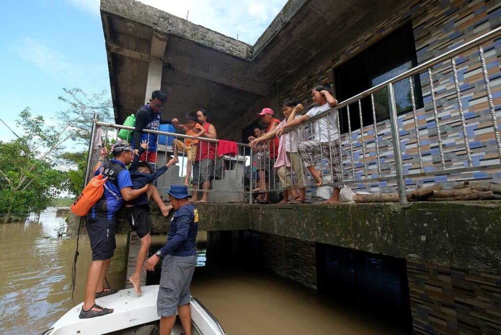 Kristine death toll rises to 110, says Office of Civil Defense. Rescuers evacuate a family from their submerged house brought about from Severe Tropical Storm Kristine in Bula town, Camarines Sur province, South of Manila on October 26, 2024. | Photo by ZALRIAN SAYAT / AFP