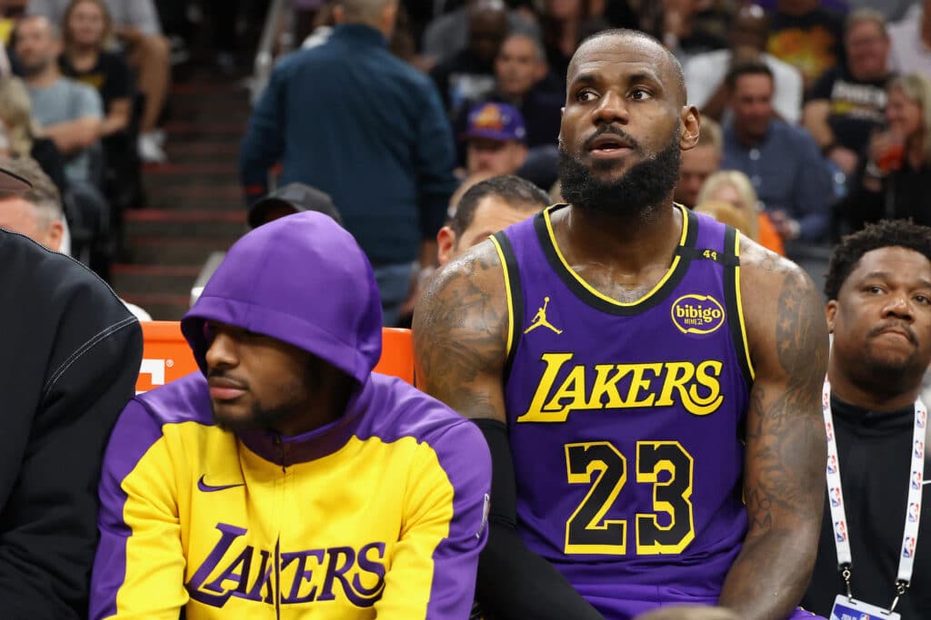 Bronny James #9 and LeBron James #23 of the Los Angeles Lakers sit on the bench during the second half of the NBA game against the Phoenix Suns at Footprint Center on October 28, 2024 in Phoenix, Arizona.| Photo by Christian Petersen /Getty Images via AFP)