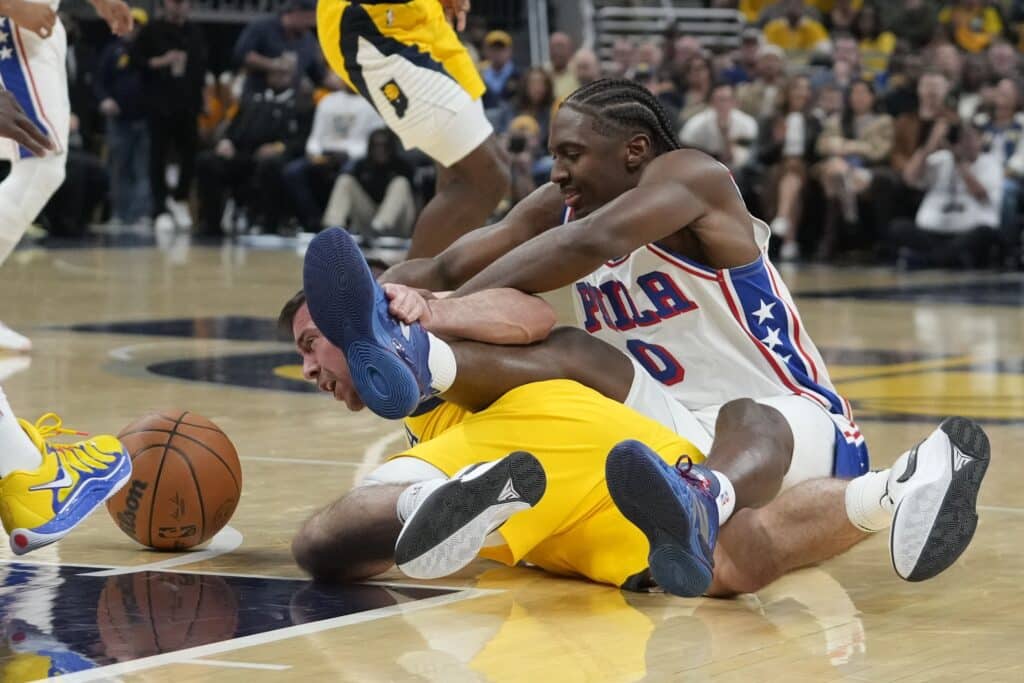 Philadelphia 76ers' Tyrese Maxey (0) and Indiana Pacers' T.J. McConnell (center left) go after the ball during the first half of an NBA basketball game, Sunday, Oct. 27, 2024, in Indianapolis. | AP Photo/Darron Cummings