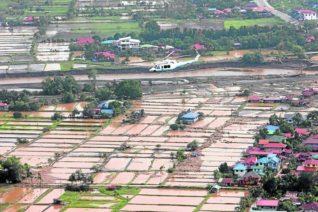 AERIAL INSPECTION Photo shows a helicopter carrying President Marcos over flooded rice fields in Batangas