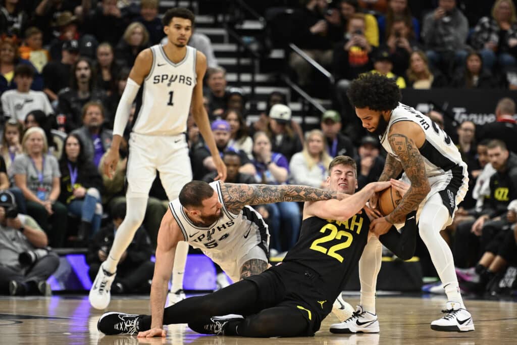 NBA: Wembanyama scores 25 to lead Spurs to a win over Jazz. Sandro Mamukelashvili #54 and Julian Champagnie #30 of the San Antonio Spurs fight for the ball with Kyle Filipowski #22 of the Utah Jazz during the second half of a game at Delta Center on October 31, 2024 in Salt Lake City, Utah. | Photo by Alex Goodlett / Getty Images via AFP