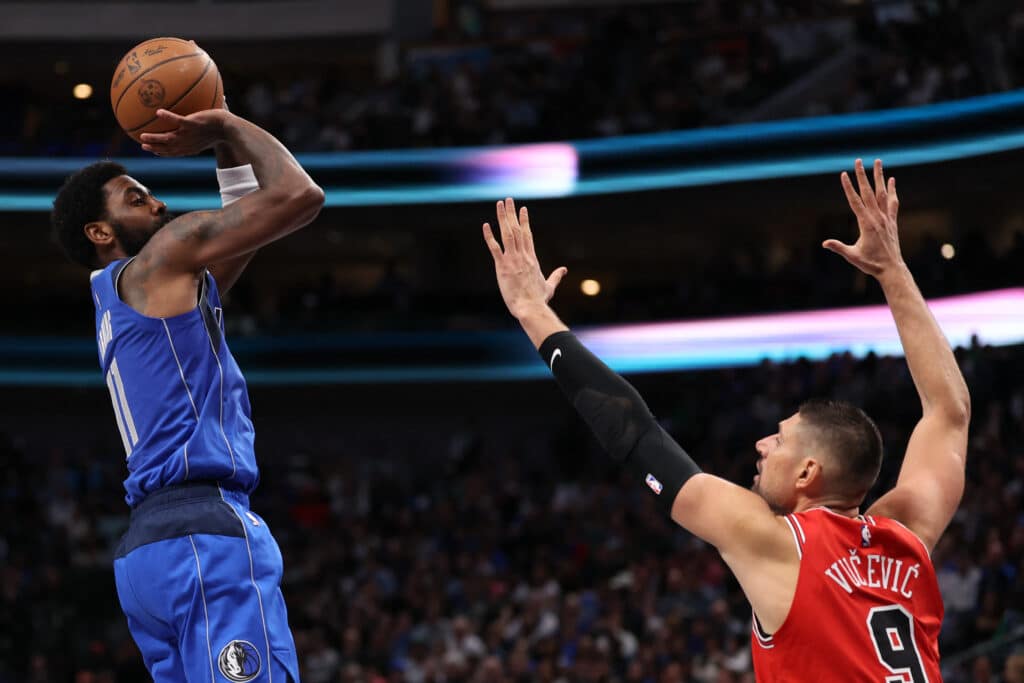 Kyrie Irving #11 of the Dallas Mavericks shoots over Nikola Vucevic #9 of the Chicago Bulls during the first half at American Airlines Center on November 06, 2024 in Dallas, Texas. | Sam Hodde/Getty Images/AFP