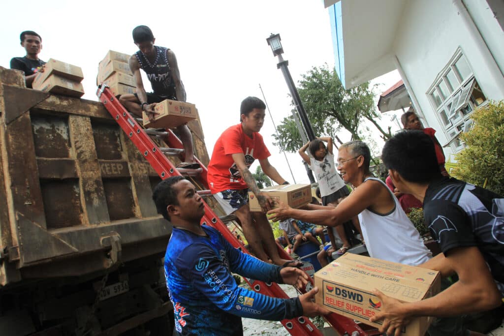 Workers unload supplies at an evacuation centre for those affected by Super Typhoon Man-yi in San Vicente town, Camarines sur province on November 17, 2024. Photo by CHARISM SAYAT / AFP