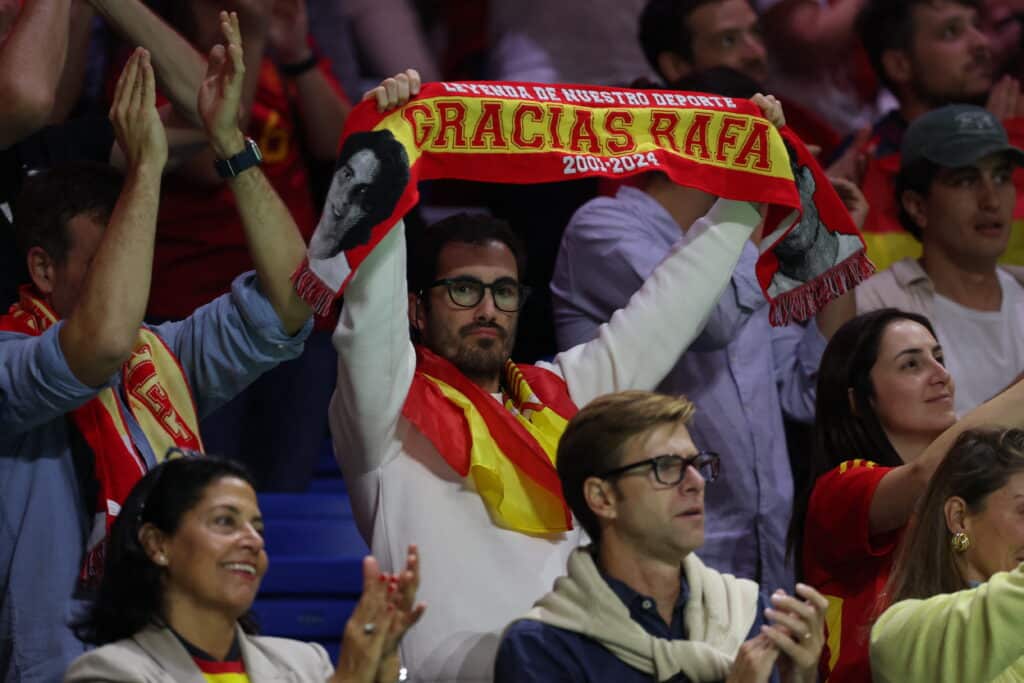 Supporters hold banners and scarves for Spain's Rafael Nadal during a tribute to his career at the end of the quarter-final doubles match between Netherlands and Spain during the Davis Cup Finals at the Palacio de Deportes Jose Maria Martin Carpena arena in Malaga, southern Spain, on November 19, 2024. | Photo by Thomas COEX / AFP