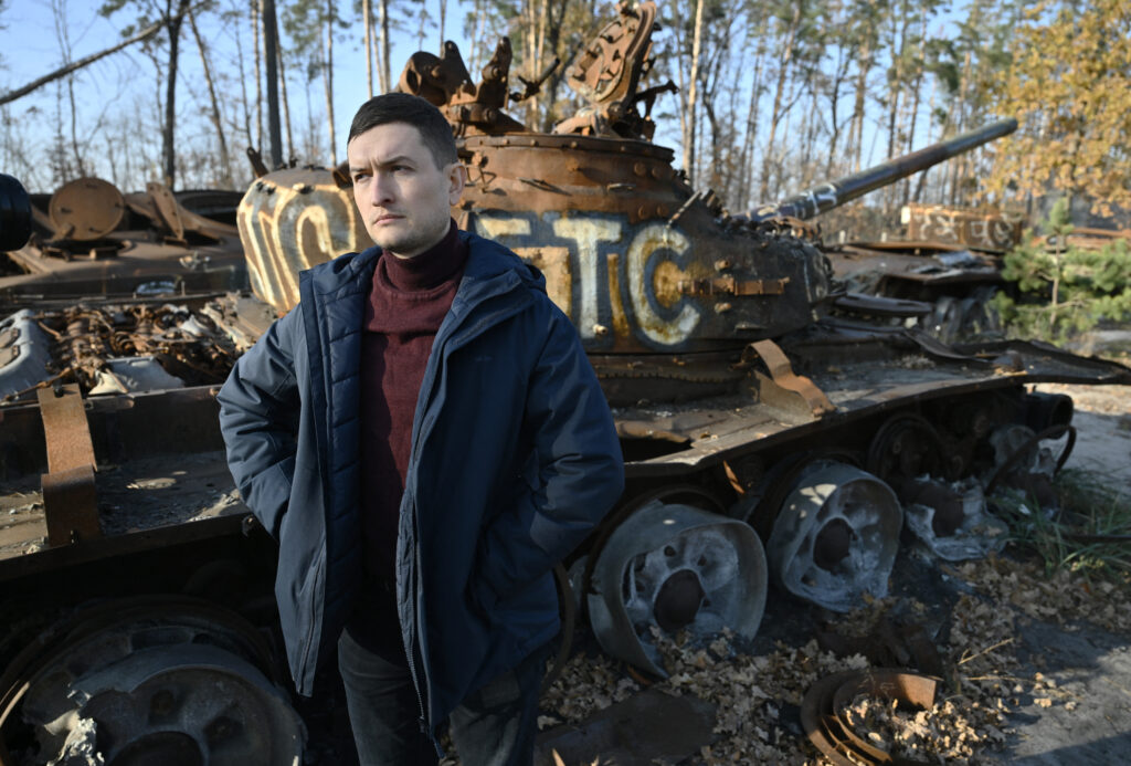 Co-founder of War Tours Dmytro Nykyforov stands next to a destroyed Russian tank at the tank graveyard during a tour near Dmytrivka village, outside Kyiv, on November 7, 2024, amid the Russian invasion of Ukraine. | Photo by Genya SAVILOV / AFP