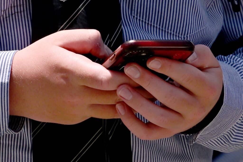 A schoolboy looks at his phone in Melbourne on November 27, 2024 as Australia looks to ban children under 16 from social media with claims social media platforms have been tarnished by cyberbullying, the spread of illegal content, and election-meddling claims.| Photo by William WEST / AFP