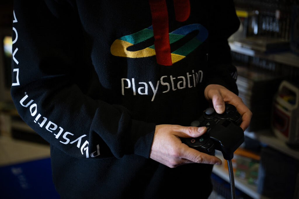 This photograph taken on November 20, 2024 shows a a PlayStation console controller, in Vraiville.| Photo by LOU BENOIST / AFP